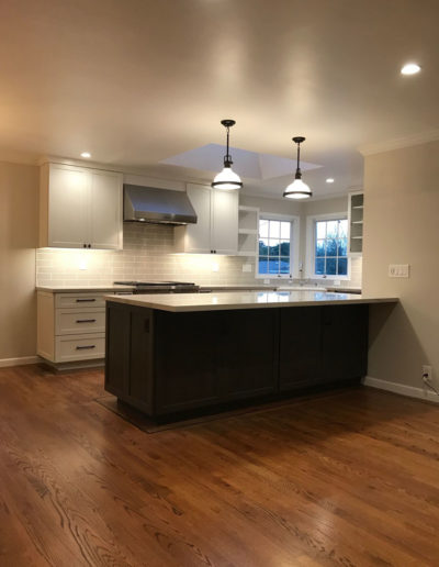 pendant kitchen lights over dark island and white cabinets