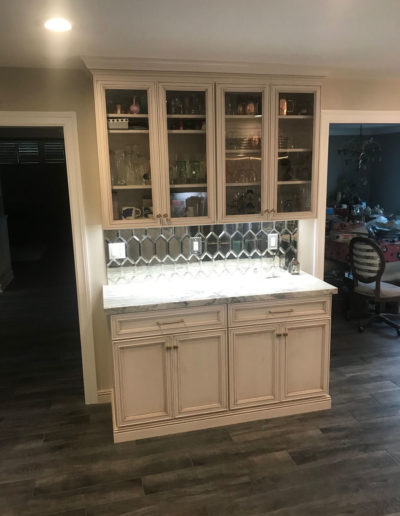 beautiful white bar area with glass cabinets