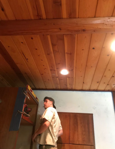 working on cabinet installation in log cabin kitchen