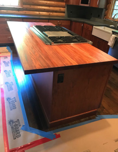 kitchen island with large stove in log cabin kitchen