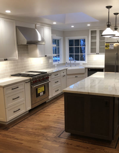 kitchen remodel with dark island and white cabinets